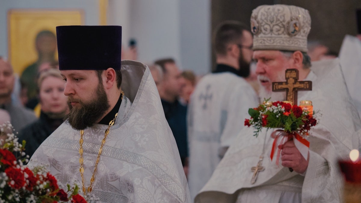 Two priests are in a religious procession.